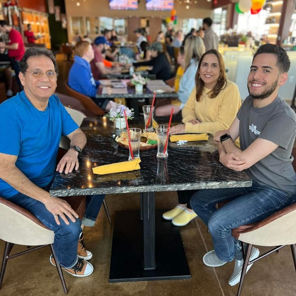 Three people smiling at a table with drinks and chips at The Reserve, a Mexican restaurant.